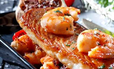 Grilled fish fillet topped with prawns and sauce, from the Fish & Seafood menu at Pistalks.